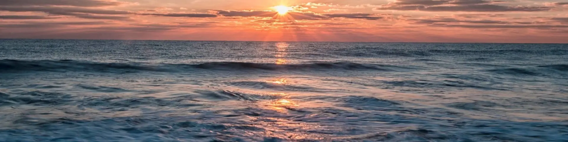 Pink and orange sunrise over ocean from Maryland shoreline